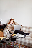 Woman on sofa using laptop