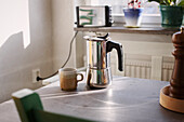 Coffee maker and cup on table