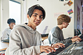 Teenagers attending keyboard lesson