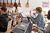 Teenagers attending keyboard lesson