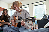 Teenagers attending guitar lesson