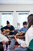 Teenagers attending guitar lesson