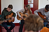 Teenagers attending guitar lesson