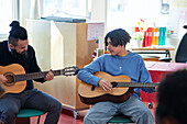 Teenagers attending guitar lesson