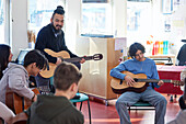 Teenagers attending guitar lesson