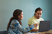 Coworkers in boardroom using laptop