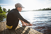 Smiling woman washing feet in lake