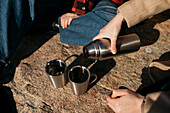 Hand pouring coffee from thermos