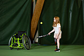 Mädchen mit Beinprothese beim Tennisspielen