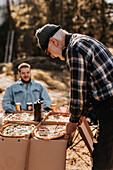 Senior man having pizza outdoors