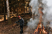 Woman burning branches in forest
