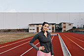 Young woman standing at running track