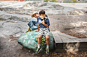 Portrait of child friends sitting on painted rock