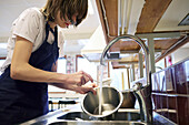 Junge Frau in der Küche beim Geschirrspülen