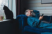 Man and black cat relaxing in living room