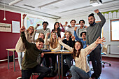 Portrait of students and teachers cheering in class