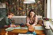 Mother with children sitting at table