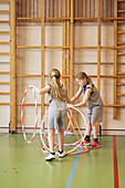 Children playing with hula hoops in school gym