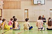 Kinder haben Unterricht in der Schulsporthalle