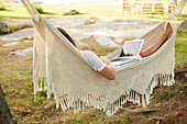 Woman using laptop in hammock