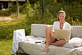 Woman using laptop on garden bench