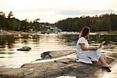 Woman using laptop at lake