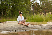 Woman using laptop at lake