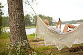 Woman using phone on hammock