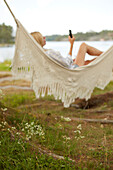 Woman using phone on hammock