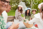 Familie mit Blumenkränzen beim Picknick