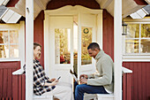 Couple sitting in front of wooden house