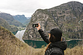 Junge Frau blickt auf einen Fjord