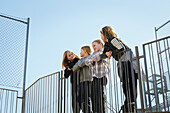 Children leaning against railing