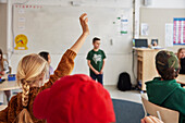 Mädchen mit erhobener Hand im Klassenzimmer