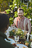 Smiling man at table in garden