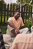 Smiling man sitting in garden