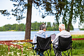 Senior couple sitting in camping chairs