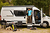 Man camping with dog in camper van