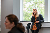 Businesswoman talking via cell phone in office