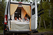 Friends lying in camper van in forest
