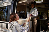 Women in camper van cleaning dishes