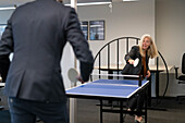 Business people playing tennis table in office