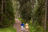 Female couple walking in forest with bicycle