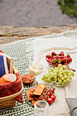 Fruit, vegetables, and crackers on picnic blanket