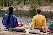 Female couple having picnic by river