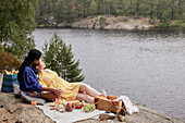 Female couple having picnic by river
