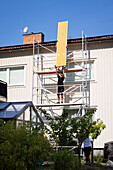 Men on scaffolding renovating house