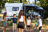 Children playing ball game on camping