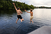 Brothers jumping into lake