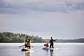 Mother and children paddle boarding